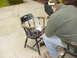 1989 Ford Bronco - A person welds metal components onto a wooden chair outdoors.