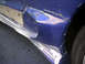 1993 Ford Probe - The side of a blue vehicle shows significant damage, including bent metal and missing paint.