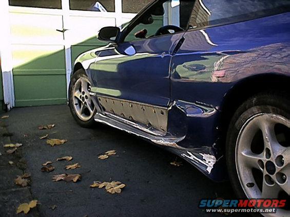 Blue car with significant damage to the lower side panel and rocker area