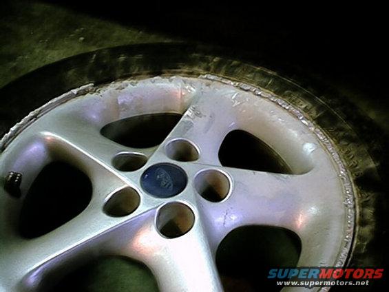 Close-up of a silver five-spoke wheel with a Ford logo in the center