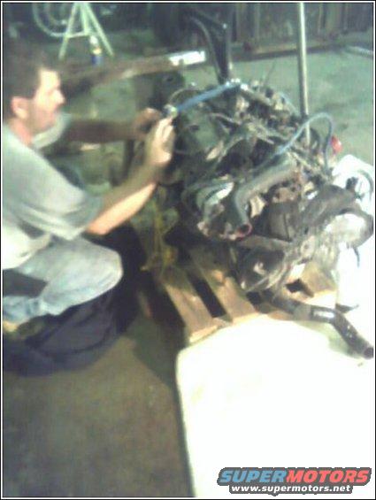 man working on engine assembly on a pallet