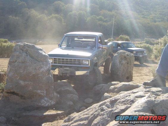Ford Ranger pickup truck navigating rocks on a trail. Another truck is behind it