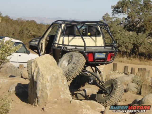 Off-road vehicle with roll cage on rocks, rear view. License plate 2MB606