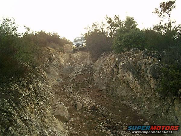 White SUV on a steep, rocky dirt road