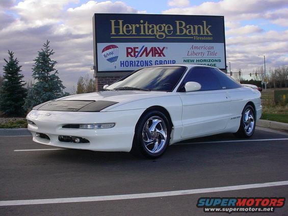 White 1996 Ford Probe parked in front of a Heritage Bank sign