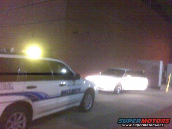 Security van parked next to a white car at night