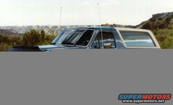 Blue and tan Ford Bronco, front quarter view, showing hood scoop and side window