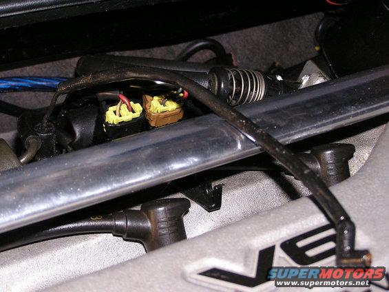 Close-up of yellow and brown electrical connectors and wiring under a car's hood