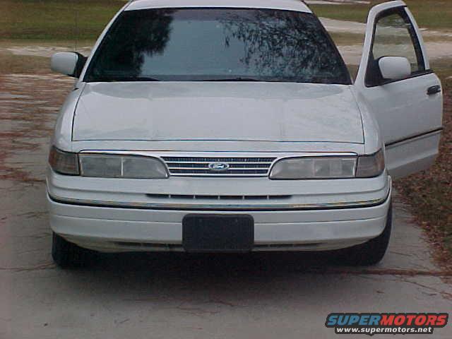 White 1992 Ford Crown Victoria, front view, driver's door open, slight damage to front bumper