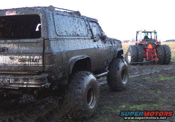 muddy SUV being pulled by a tractor