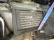 1993 Mazda MX-3 - Close-up of a vehicle's engine bay shows a damaged cooling component secured by a strap.