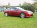 1993 Mazda MX-3 - Red 1993 Mazda MX-3 coupe with aftermarket wheels sits on a grassy lawn.