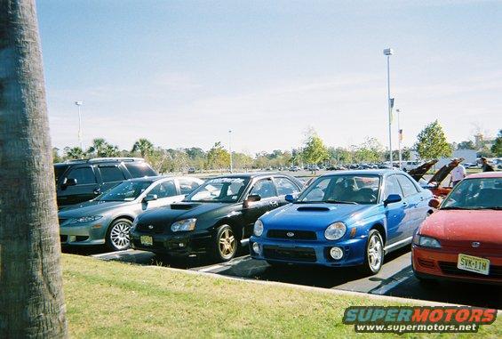 Blue Subaru WRX parked in a lot with other cars