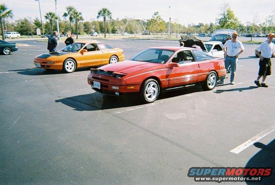 Red 1991 Ford Probe parked next to an orange one in a lot