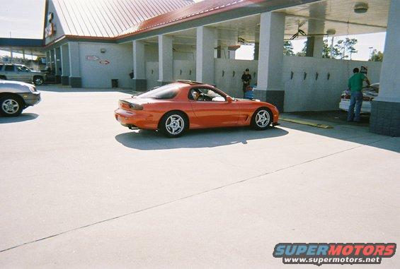 Orange Mazda RX-7 parked at a car wash