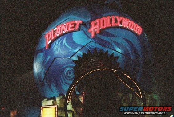 Planet Hollywood globe entrance at night with neon sign