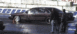 1995 Chevrolet Impala - A dark-colored sedan is positioned on a wet surface, possibly a race track, with two individuals observing.