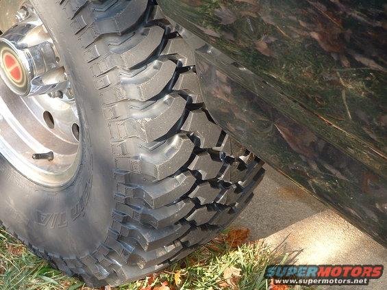 1994 Ford Bronco tire and fender with chrome hubcap and off-road tire