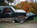 1988 Ford Bronco - 1988 Ford Bronco and a sedan are parked on a dirt path during autumn.