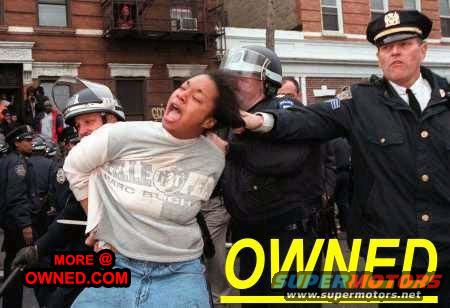 Police officers arresting a person in front of a brick building, with text overlay 'OWNED SUPERMOTORS'