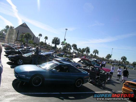 Teal 1993 Ford Probe coupe with black wheels parked in a lot, front 3/4 view