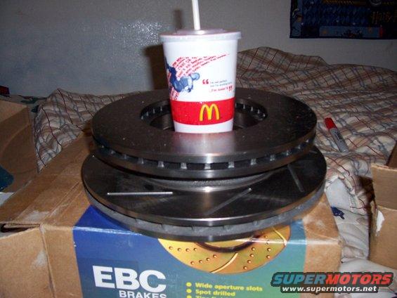 Two brake rotors stacked on a box with a McDonald's cup on top