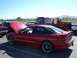 1997 Ford Probe - A red coupe, possibly a Ford Probe, is parked with its hood open at an outdoor event, showing racing numbers on the window.