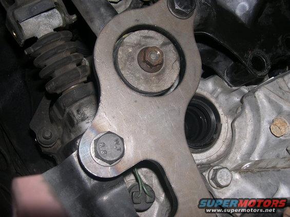 Close-up of clutch slave cylinder assembly with bolts and metal bracket