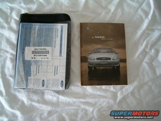 Ford Taurus owner's guide and roadside assistance documents on white cloth