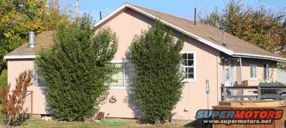 House with trees in front and a hot tub on the deck. Supermotors logo visible