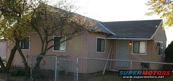 House with chain-link fence and trees
