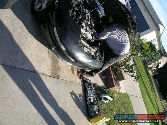 1993 Ford Probe with hood open, man working on engine, tools laid out