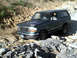 1996 Ford Bronco - The 1996 Ford Bronco navigates a challenging off-road terrain with steep inclines and loose rocks.