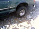 1996 Ford Bronco - The vehicle is navigating a rocky, uneven surface, with its front passenger-side wheel visible.