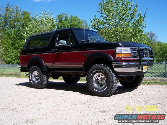 Two-tone black and maroon Ford Bronco with chrome wheels and off-road tires