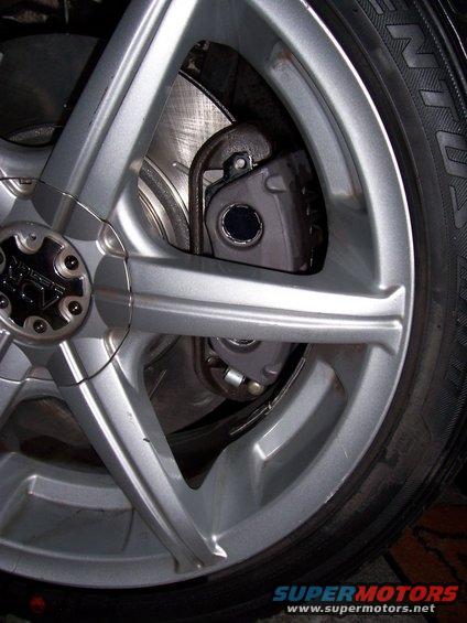 Silver alloy wheel with brake caliper and rotor visible