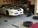 1996 Ford Probe - A white 1996 Ford Probe is undergoing maintenance in a cluttered garage.