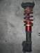 1996 Ford Probe - A red coilover suspension part is shown against a concrete surface.