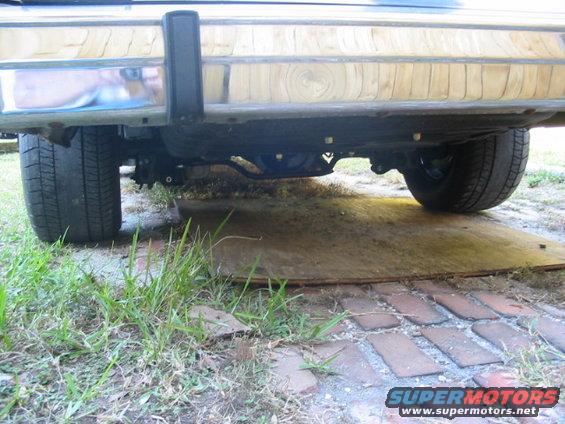 Underside view of a car's rear bumper, differential, and tires