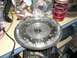 1996 Ford Probe - A car part, likely a flywheel, is shown on a cluttered workbench with other automotive components.