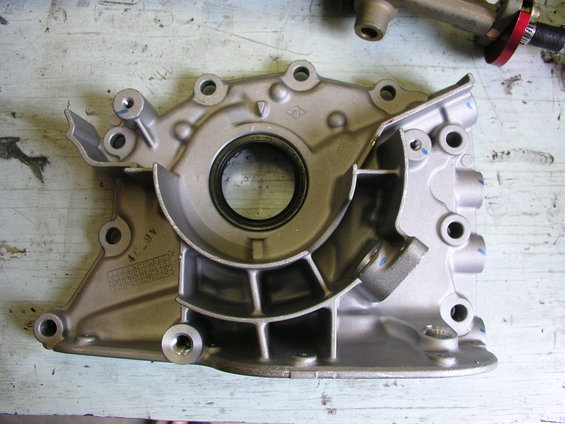 Engine oil pump housing with casting marks and a seal