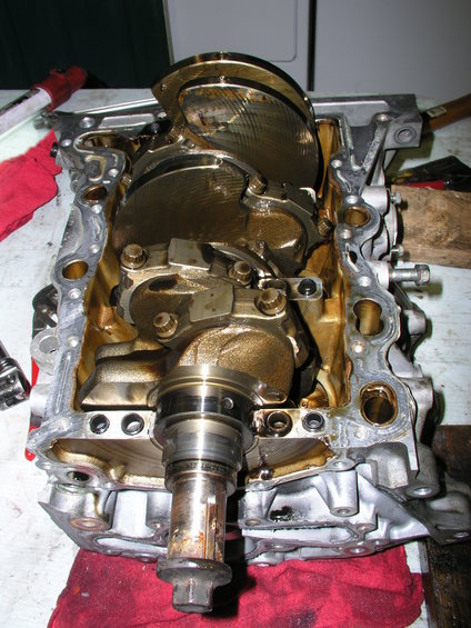 Engine block with crankshaft exposed, showing internal components and oil residue