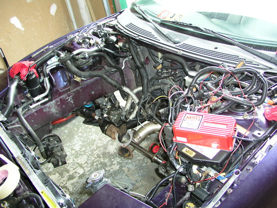 Engine bay with turbocharger piping and red MSD ignition box