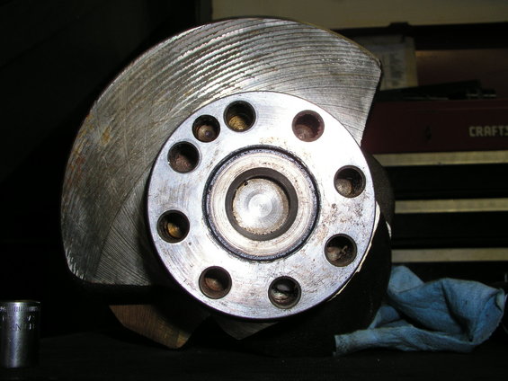 Close-up of a crankshaft with a bolt pattern visible