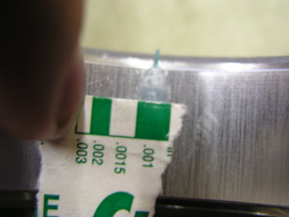 Feeler gauge measuring clearance on a metal engine component