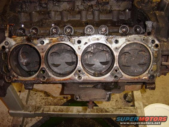 dsc00494.jpg Passenger side of block, with head gasket still in place.  Both block drain plugs were stripped, so we had to drain the water jackets by siphoning through a lower head bolt hole -- hence the coolant in the #4 cylinder, which leaked in as we were taking the head off.