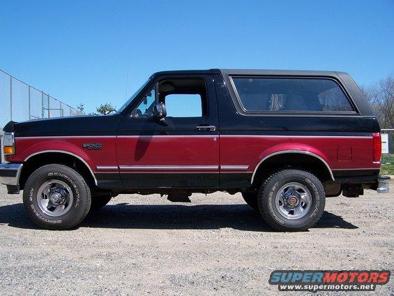 Two-tone black and red Ford Bronco SUV, side view. Chrome trim and wheels