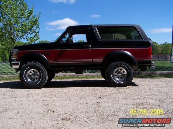 Side view of a red and black 1994 Ford Bronco with BFGoodrich All-Terrain tires