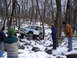 1989 Ford F-350 - A modified light blue off-road vehicle tackles a snowy, rocky trail with onlookers observing.