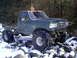 1989 Ford F-350 - This modified 1989 Ford F-350 sits on large tires amidst a snowy, rocky terrain.